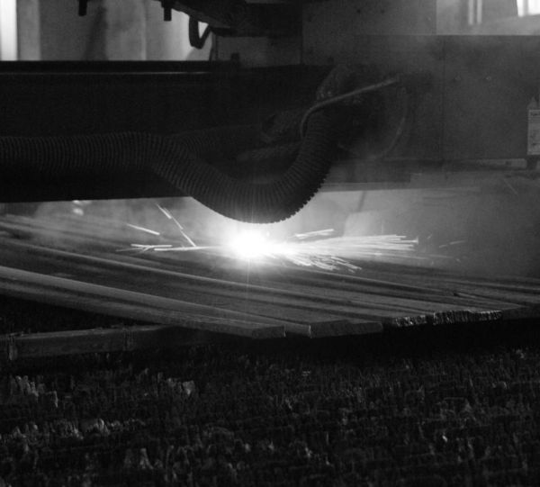 Станок плазменной резки металла в работе. На фото изображен процесс изготовления ножей из высоколегированной стали для сельскохозяйственной техники.